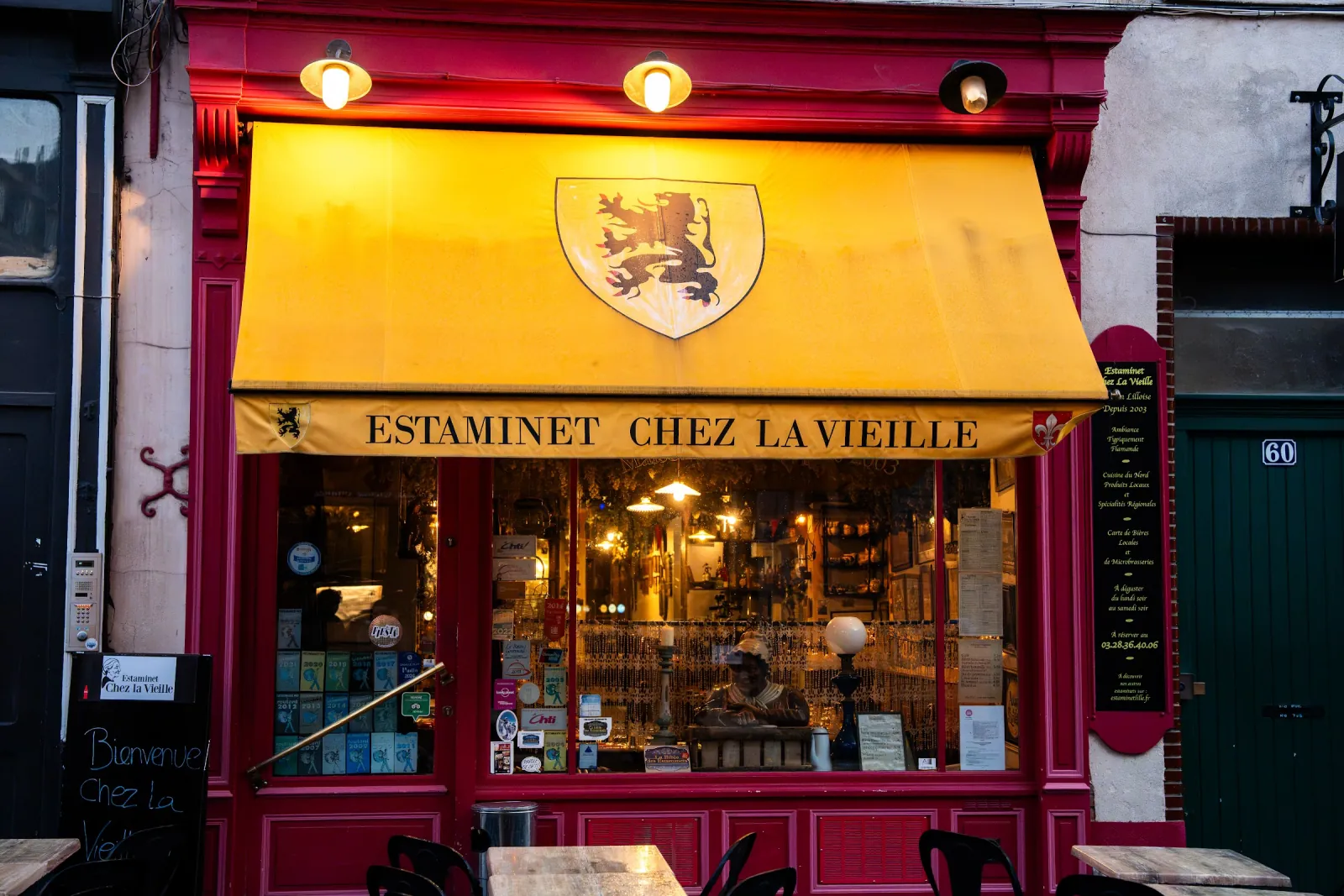La façade rouge de Chez la Vieille, rue de Gand, son store jaune frappé du lion des Flandres et sa vitrine éclairée.